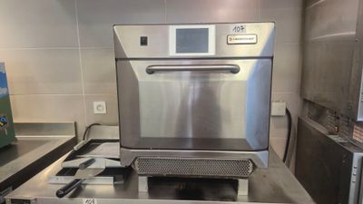 un four en acier inoxydable posé sur un plan de travail dans une cuisine
