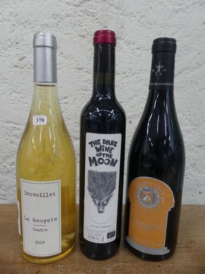 plusieurs bouteilles de vin sont alignées sur une table en bois