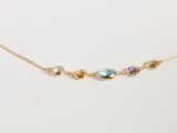 un collier en or orné de pierres multicolores sur fond blanc