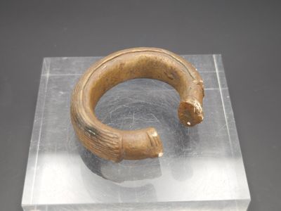 une photo d'un bracelet en bois posé sur un bloc de verre
