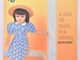 La poupée porte une robe bleue et un chapeau de paille.