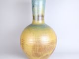 a yellow and blue vase sitting on a white surface
