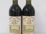 two bottles of wine sitting on top of a table next to each other