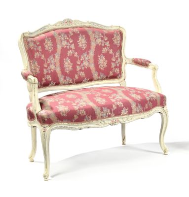 a pink and white chair with a floral upholstered back
