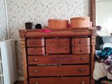 a dresser and a mirror in a room with a floral wallpaper