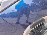 a reflection of a man walking on the side of the road