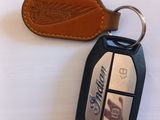 a leather keychain and a leather keyring on a white surface