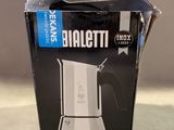 emballage d'une cafetière à lait posée sur une table à côté d'une tasse