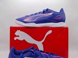une paire de chaussures Puma posée sur une boîte rouge