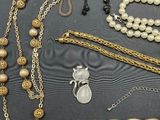 many different types of necklaces and bracelets laid out on a table