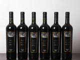 six bouteilles de vin sont alignées sur une table en bois