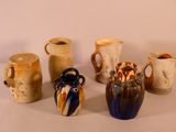 five different vases sitting on a table with a white background