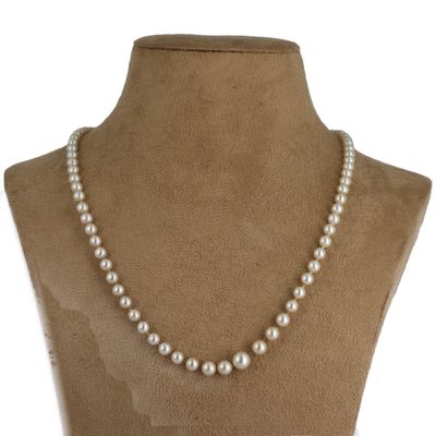 un gros plan d'un mannequin portant un collier de perles blanches