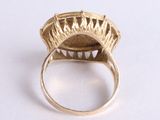 an image of a gold ring on a white surface