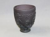 a purple glass cup with a dragon design on it