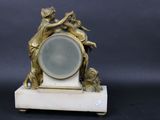 a small clock with a statue on top of it
