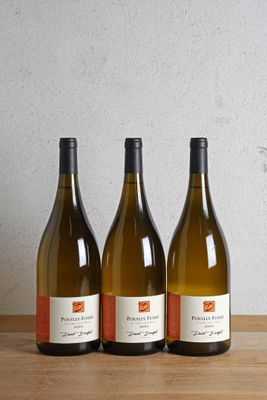 trois bouteilles de vin posées sur une table en bois