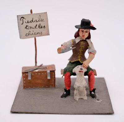 a figurine of a woman sitting on a bench with a dog