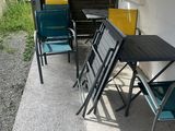 a table and two chairs on the porch of a house