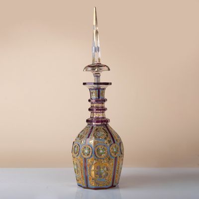 a glass bottle that has a candle on top of it