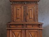 un vieux meuble en bois avec des sculptures et des gravures sur le dessus