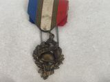 three medals are displayed in small boxes on a white surface