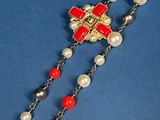 a close up of a rosary with red and white beads