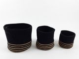 three black and brown striped baskets sitting on top of a white surface
