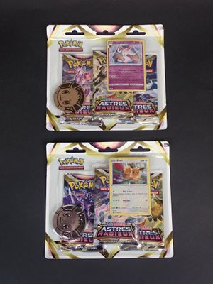 deux paquets de cartes à collectionner Pokémon posés sur une surface noire