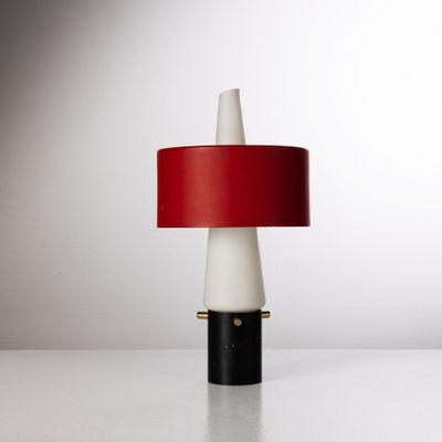 une lampe de table blanche et rouge, dotée d'un abat-jour rouge