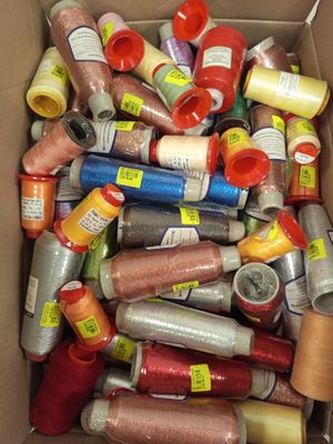 many spools of thread in a box on the floor