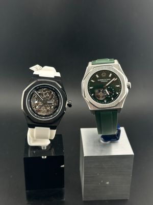Deux montres sont posées sur un support, sur une surface noire.