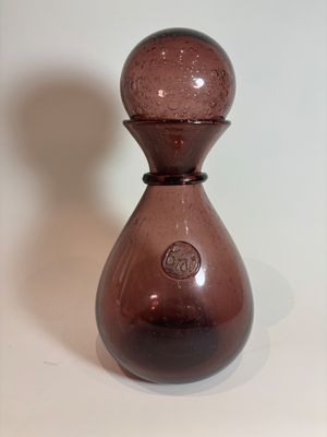 a brown glass vase sitting on a white surface
