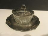 a silver plate with a glass covered dish on it