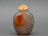 un vase en verre orné d'une fleur, posé sur une surface grise