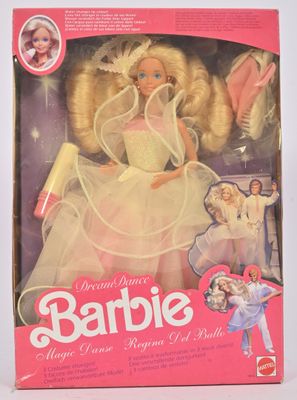 La poupée Barbie se trouve dans sa boîte, avec son emballage, sur la table.