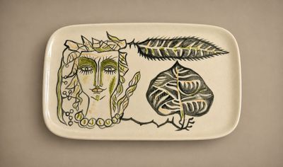 une assiette sur laquelle est représentée une femme et un oiseau
