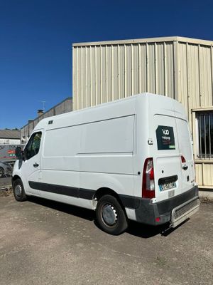 la camionnette blanche est garée devant un bâtiment dans un parking