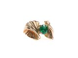 gros plan d'une bague en or avec une pierre verte
