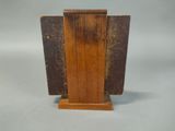 an old book with a wooden stand on a gray surface