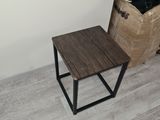 a small table with a wooden top next to a basket