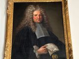 a painting of a man holding a book on a wall