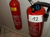 un extincteur fixé au mur à côté des toilettes