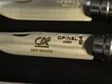 two knives that are sitting on a black surface