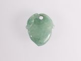 a close up of a green jade heart shaped object on a white surface