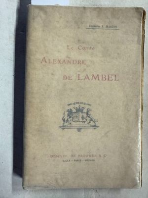 un vieux livre posé sur une table blanche à côté d'un livre noir