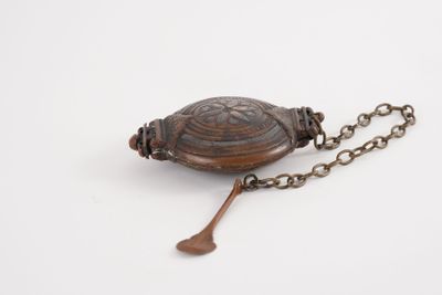 une image représentant une tortue en bois suspendue à une chaîne sur un fond blanc
