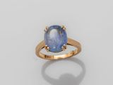 a gold ring with a blue stone in the center