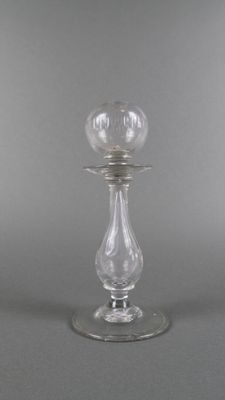 une image représentant un bougeoir en verre sur fond gris