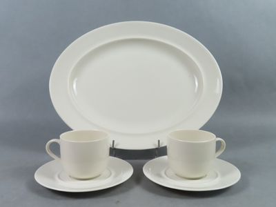 deux tasses et soucoupes sont posées sur une assiette, sur une table